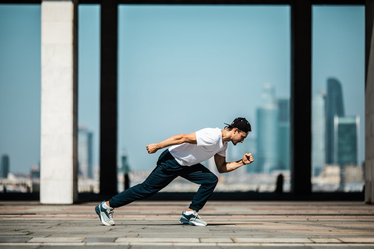 portfolio-06 Dynamic shot of a young man sprinting outdoors in an urban setting with skyscrapers in the background.